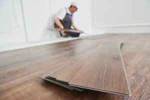 Homem instalando piso vinílico click em um apartamento