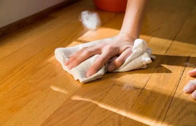 Pessoa removendo mancha de piso laminado
